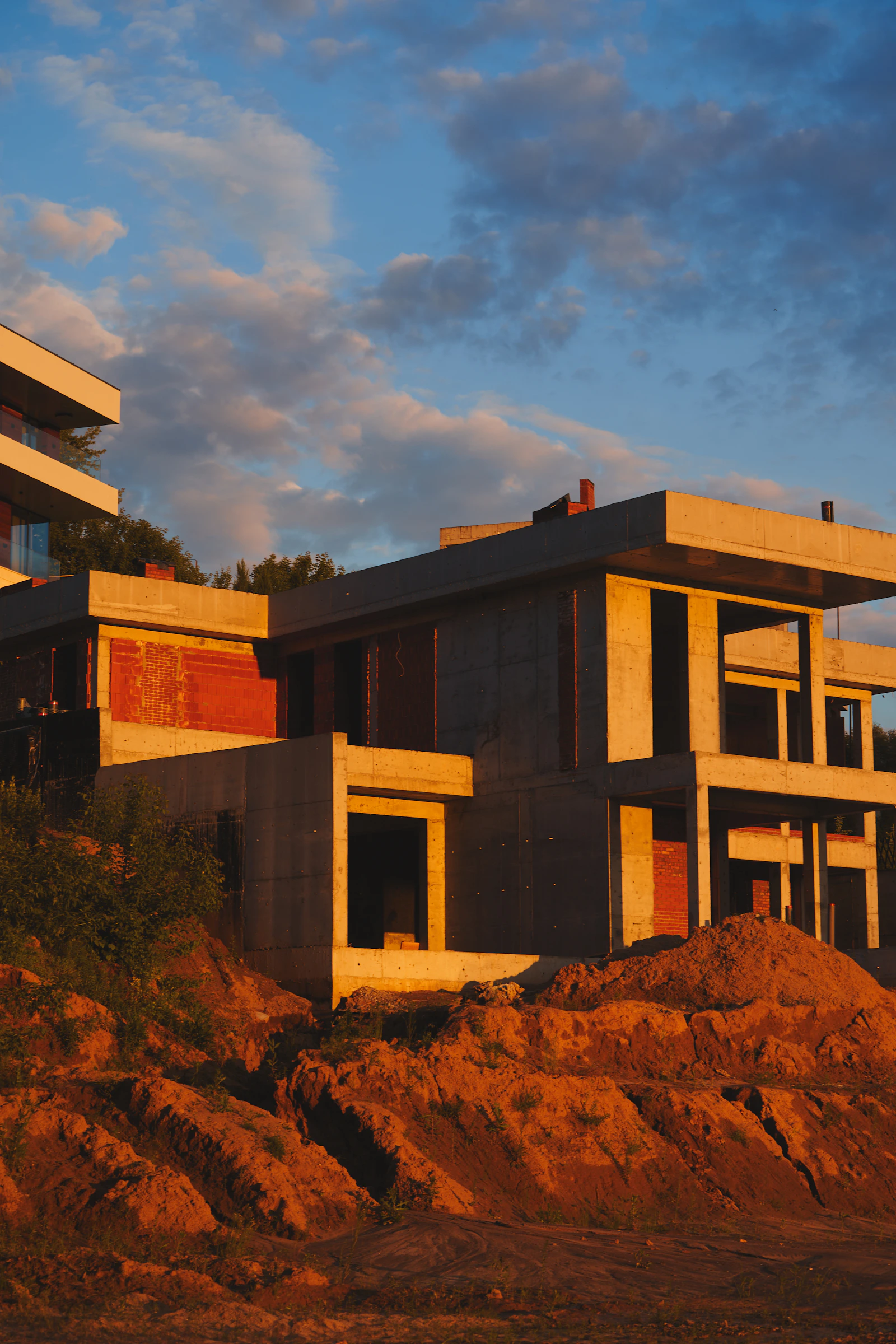 Construcción de concreto y ladrillo sobre una ladera al atardecer