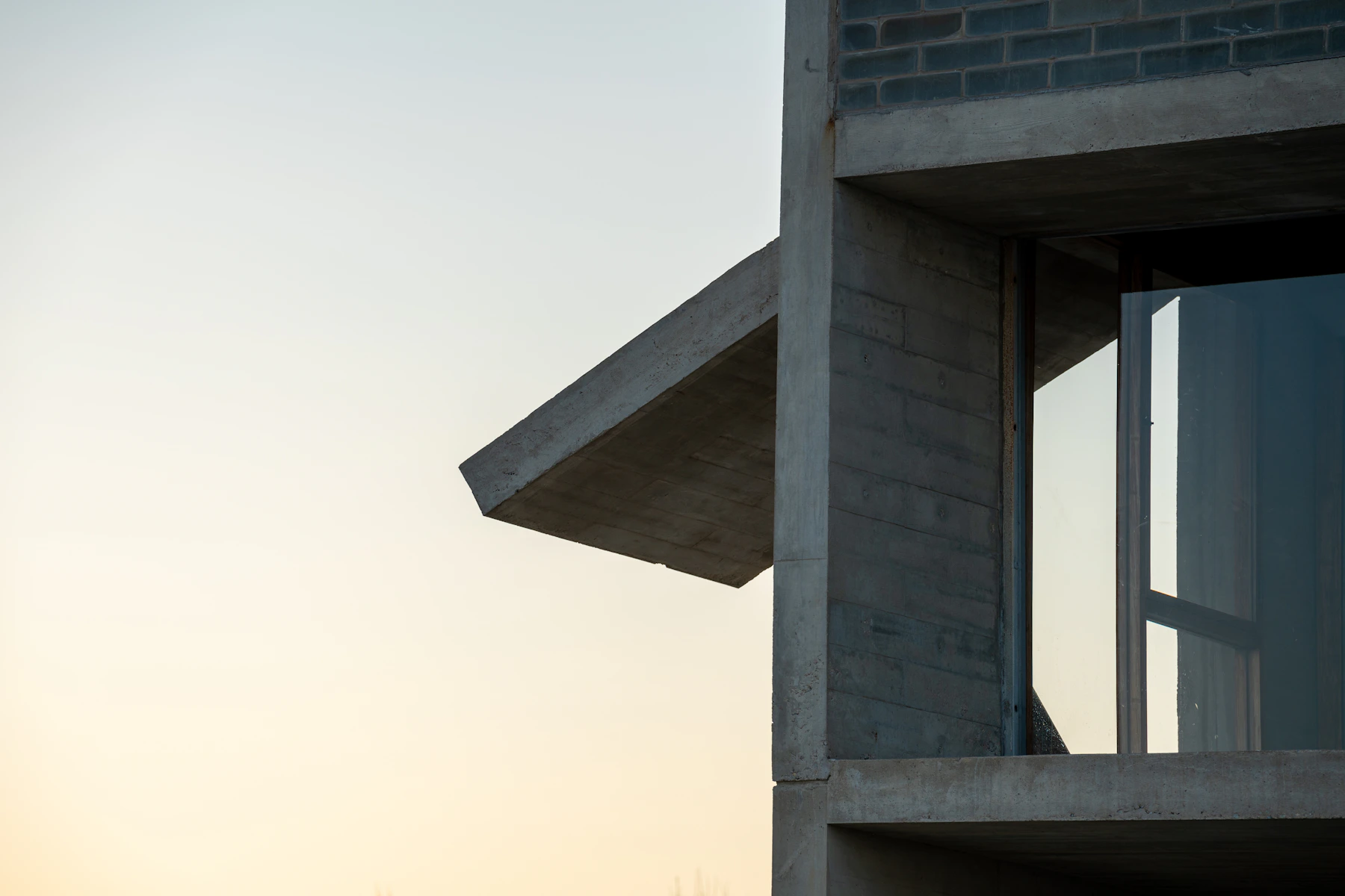 Volúmenes de concreto y un voladizo vistos desde el exterior