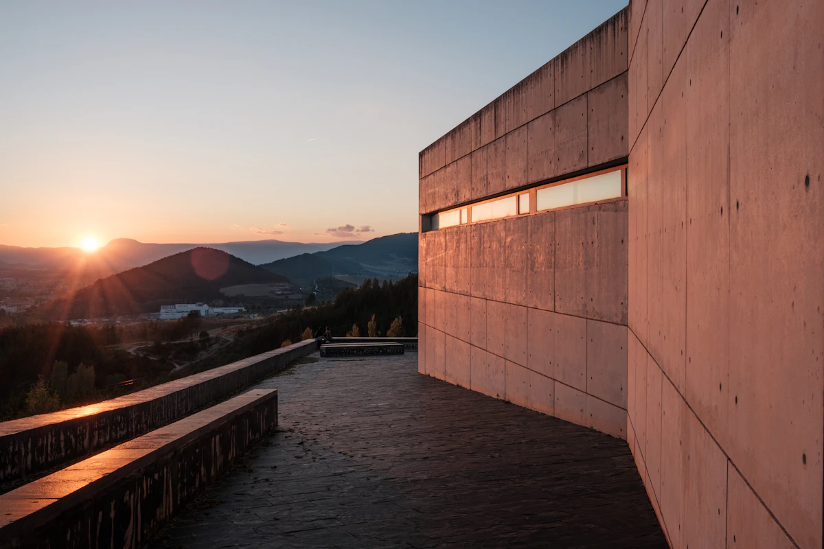Fachada contemporánea de concreto frente a un paisaje de montañas